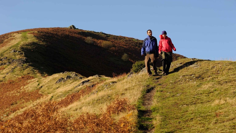Visitors enjoying the autumn sunshine at Carding Mill Valley and the Shropshire Hills, Shropshire. The site covers 2000 hectares of heather-covered hills featuring iconic views of the Shropshire Hills.